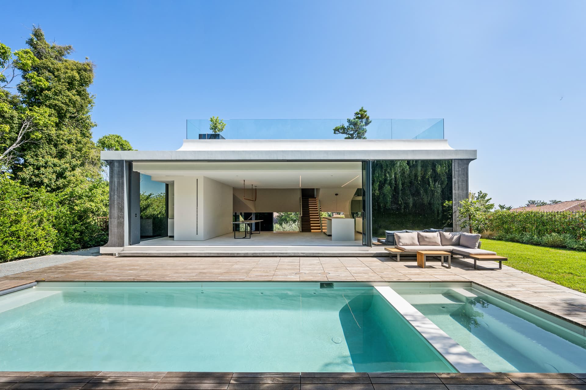 A contemporary glass-fronted vacation home with a swimming pool