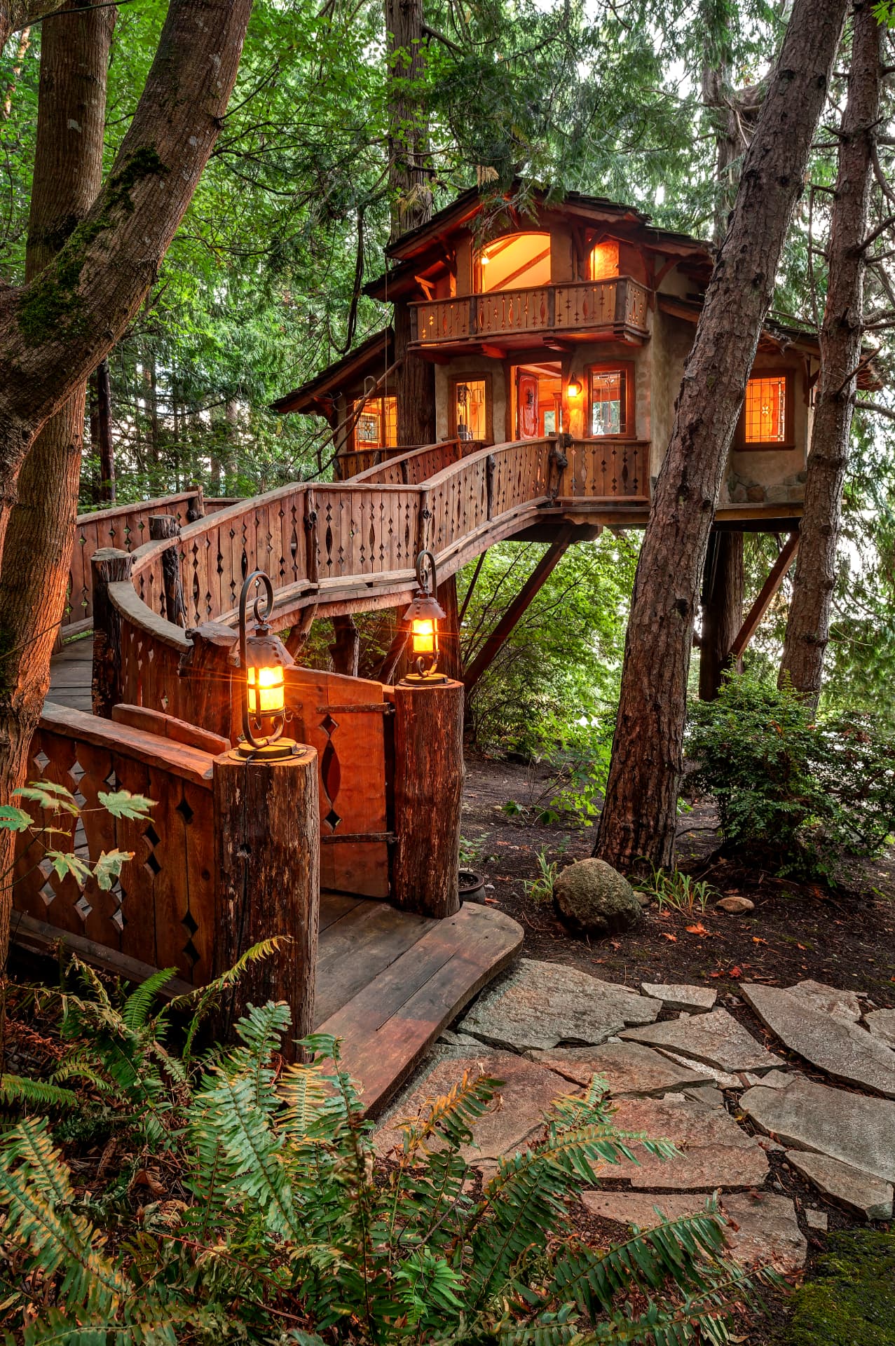 A glowing wooden treehouse tucked among tall forest trees