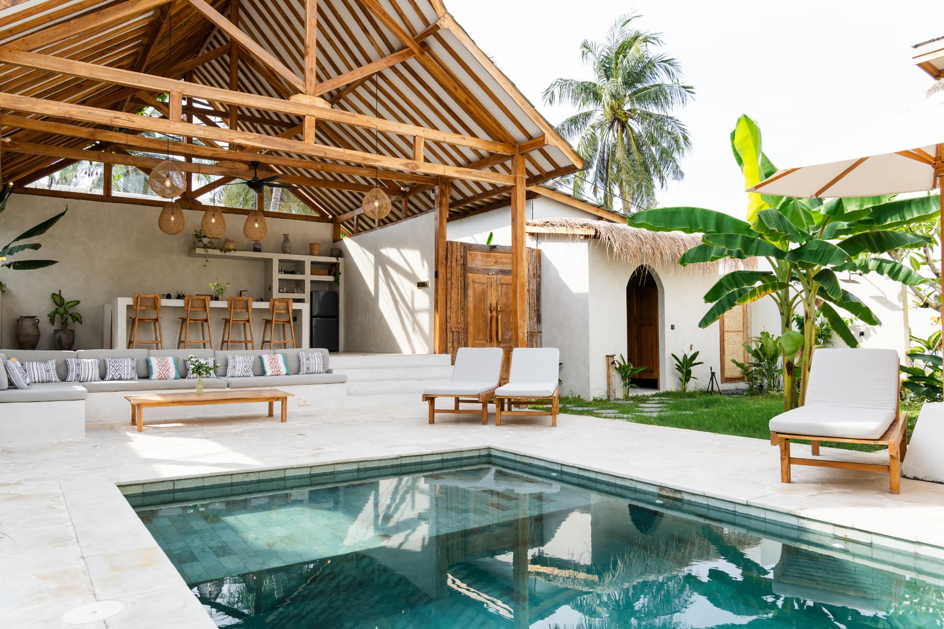 Open-air tropical villa living space beside a private pool